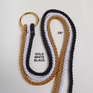 May include: Three twisted ropes in gold, white, and black, each measuring 3/8 inches in diameter, are looped through a single circular gold metal ring. The text GOLD WHITE BLACK is printed near the ropes, indicating the available color options.