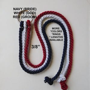 Peut inclure: Trois cordes torsad&eacute;es de 3/8 de pouce d'&eacute;paisseur en bleu marine, blanc et rouge, fix&eacute;es &agrave; un anneau m&eacute;tallique. Le texte indique : NAVY (BRIDE) WHITE (GOD) RED (GROOM) et MORE: *COLORS *RINGS *LENGTHS AVAILABLE. Les extr&eacute;mit&eacute;s sont nou&eacute;es.