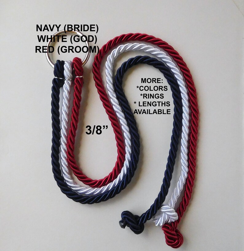 Peut inclure: Trois cordes torsad&eacute;es de 3/8 de pouce d'&eacute;paisseur en bleu marine, blanc et rouge, fix&eacute;es &agrave; un anneau m&eacute;tallique. Le texte indique : NAVY (BRIDE) WHITE (GOD) RED (GROOM) et MORE: *COLORS *RINGS *LENGTHS AVAILABLE. Les extr&eacute;mit&eacute;s sont nou&eacute;es.