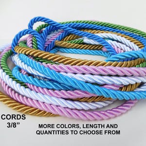 Könnte beinhalten: Eine Sammlung gedrehter Dekokordeln in verschiedenen Farben wie Blau, Grün, Gold, Weiß und Lavendel. Die Kordeln haben einen Durchmesser von 0,95 cm. Der Text auf dem Bild lautet: CORDS 3/8" MORE COLORS, LENGTH AND QUANTITIES TO CHOOSE FROM.