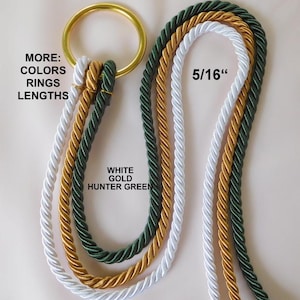 Op de afbeelding: Decoratief touw in wit, goud en jagergroen, bevestigd aan een gouden ring. Het touw is 0,8 cm dik. Tekst op de afbeelding luidt "MORE: COLORS RINGS LENGTHS" en "WHITE GOLD HUNTER GREEN".