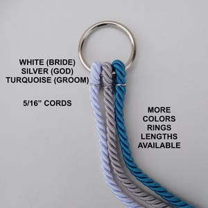 Op de afbeelding: Een zilveren metalen ring houdt drie gedraaide koorden in wit, zilver en turquoise vast. Tekst op de afbeelding luidt "WHITE (BRIDE), SILVER (GOD), TURQUOISE (GROOM), 5/16" CORDS, MORE COLORS RINGS LENGTHS AVAILABLE."