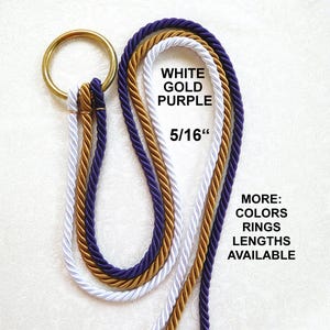 Op de afbeelding: Decoratief touw in wit, goud en paars, met een gouden ring. De tekst op de afbeelding luidt "WHITE GOLD PURPLE 5/16"" en "MORE: COLORS RINGS LENGTHS AVAILABLE." Het touw is ongeveer 0,8 cm dik.