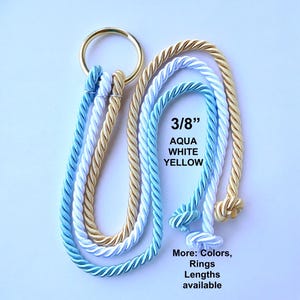 Peut inclure: Trois cordes torsad&eacute;es de couleur aqua, blanc et jaune, d'un diam&egrave;tre de 3/8 pouce, fix&eacute;es &agrave; un anneau m&eacute;tallique dor&eacute;. Les cordes forment des boucles avec des extr&eacute;mit&eacute;s nou&eacute;es. Le texte indique 3/8 pouce, AQUA WHITE YELLOW, et More: Colors, Rings, Lengths available.