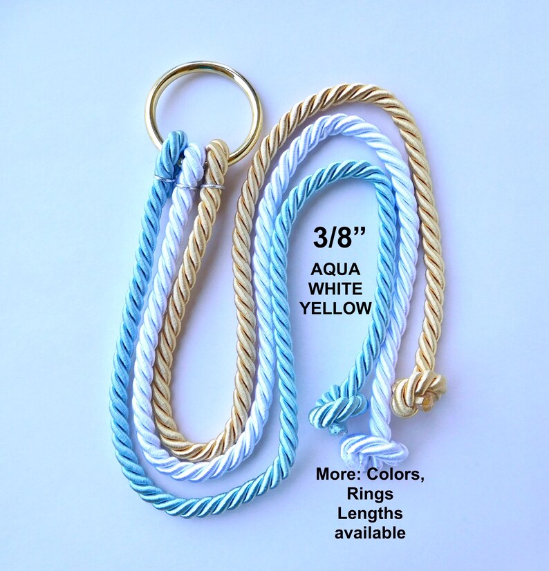 Peut inclure: Trois cordes torsad&eacute;es de couleur aqua, blanc et jaune, d'un diam&egrave;tre de 3/8 pouce, fix&eacute;es &agrave; un anneau m&eacute;tallique dor&eacute;. Les cordes forment des boucles avec des extr&eacute;mit&eacute;s nou&eacute;es. Le texte indique 3/8 pouce, AQUA WHITE YELLOW, et More: Colors, Rings, Lengths available.