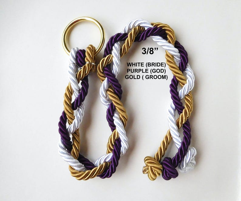 Peut inclure: Une corde tress&eacute;e compos&eacute;e de trois brins de couleur blanche, violette et dor&eacute;e, fix&eacute;e &agrave; un anneau en m&eacute;tal dor&eacute;. Le texte 3/8&rdquo;, WHITE (BRIDE), PURPLE (GOD), GOLD (GROOM) est imprim&eacute; sur l'image, indiquant un diam&egrave;tre de 3/8 de pouce.