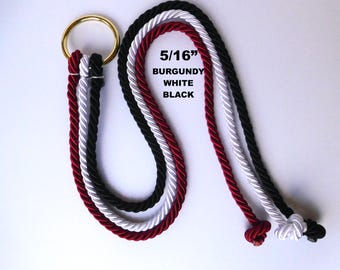 May include: A 5/16 inch rope set featuring three twisted cords in burgundy, white, and black, all secured to a single gold-toned metal ring. Each cord ends in a small knot, and the text 5/16 BURGUNDY WHITE BLACK is printed clearly on the image.