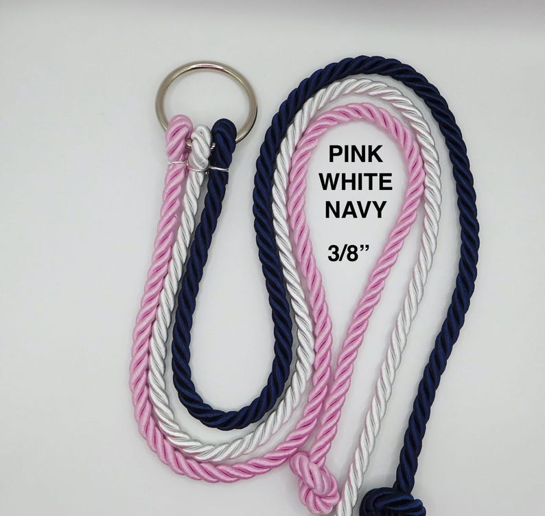 Peut inclure: Un ensemble de trois cordes torsad&eacute;es rose, blanche et bleu marine, fix&eacute;es &agrave; un anneau m&eacute;tallique argent&eacute;. Les cordes ont un diam&egrave;tre de 0,95 cm et portent le texte imprim&eacute; PINK WHITE NAVY 3/8" sur la section de la corde blanche.