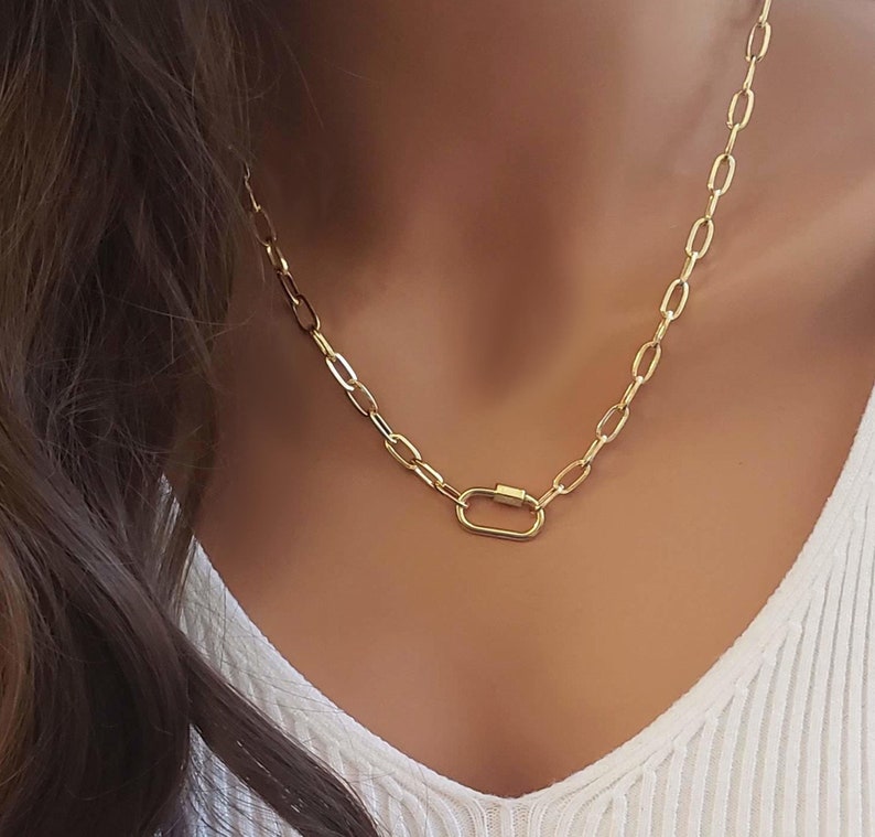 Puede incluir: Un collar de cadena dorada con un cierre ovalado dorado.