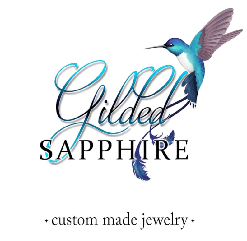 May include: The Gilded Sapphire logo features a hummingbird in shades of blue and purple, with the words "Gilded Sapphire" in elegant script. Below, the text reads "custom made jewelry."