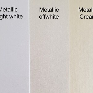 Puede incluir: Tres muestras de papel met&aacute;lico en diferentes tonos de blanco: blanco brillante, blanco roto y crema.