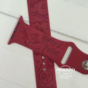 Pode incluir: Pulseira vermelha para Apple Watch com tema Harry Potter. A pulseira é gravada com imagens de Harry Potter, Hogwarts, o Expresso de Hogwarts e o símbolo das Relíquias da Morte. A pulseira também tem o texto "Harry Potter" e "9 3/4".