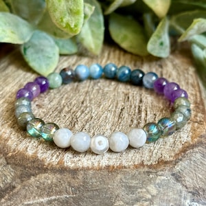 May include: A multi-colored gemstone bracelet with amethyst, labradorite, and moonstone beads. The bracelet is made with 8mm beads and is approximately 7 inches in length.