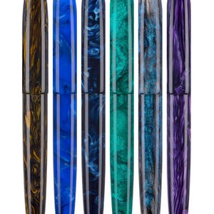 Peut inclure: Six stylos-plumes colorés avec une finition brillante. Les stylos présentent une variété de couleurs, dont le jaune et le marron, le bleu, le vert d'eau et le violet. Chaque stylo a un motif marbré unique et une bande argentée près de la plume.