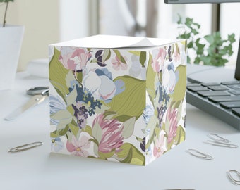 May include: A square floral patterned notepad holder with a white top. The pattern features pink, blue, green, and purple flowers on a white background.