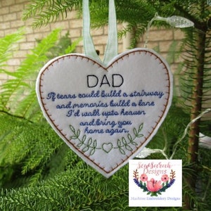 Op de afbeelding: Witte vilten hartvormige hanger met blauwe borduurwerk. De hanger heeft de tekst "DAD Als tranen een trap konden bouwen en herinneringen een weg, zou ik naar de hemel gaan en je naar huis brengen."