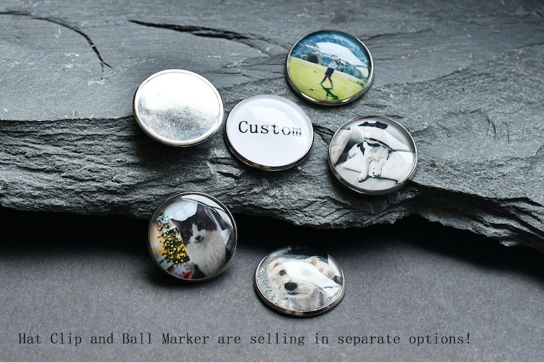 May include: Five different golf ball markers with various images. The markers are round and silver with a clear glass top. The images include a golfer, a dog, a cat, a custom text, and a blank marker.
