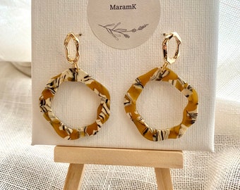 Irregular oval earrings in fine gold-plated brass adorned with an irregular pendant in ocher and white acetate