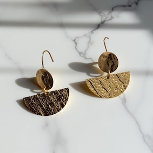 Dangle earrings adorned with a crescent moon pendant
