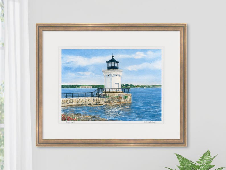 Framed watercolor art print of Bug Light staged in a bright interior, showing Portland Breakwater Light with calm blue harbor waters.