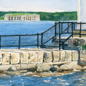 Close-up detail of Bug Light highlighting the stone breakwater, iron railing, and Fort Gorges across Portland Harbor.