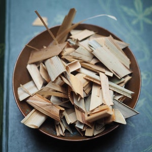May include: A copper-colored bowl filled with thin, light brown wood shavings.