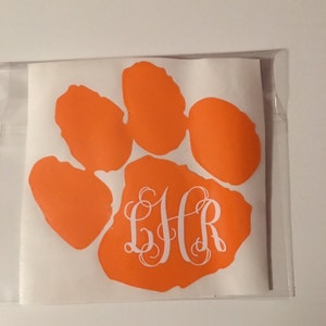 May include: Orange paw print decal with a white monogram "BHR" in the center. The decal is on a white background.