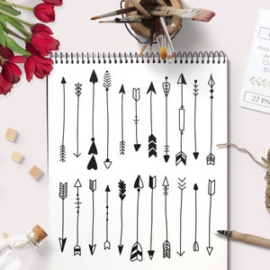 Könnte beinhalten: Ein Blatt Papier mit 22 handgezeichneten Pfeil-Designs in Schwarzweiß. Das Papier liegt auf einer weißen Oberfläche mit einer Spiralbindung oben. Der Text "BY LEF Hand drawn Arrows Clipart Black 22 PNG" befindet sich in der oberen rechten Ecke des Bildes.