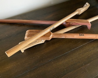 May include: Three wooden sticks with different designs and personalized names. The sticks are made of light brown wood and have a smooth finish. The names "Zach", "Bill Dad", and "Dad" are engraved on the sticks.