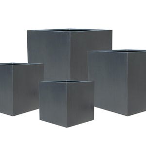 May include: A set of four dark grey, cube-shaped planters in different sizes. The planters have a simple, modern design with a smooth, matte finish. The open tops are visible, indicating they are designed for plants or decorative use. The planters are made of a durable material.