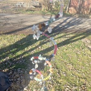 Spiral Gemstone spinner suncatcher with sparkling glass beads and rough Emerald pendant