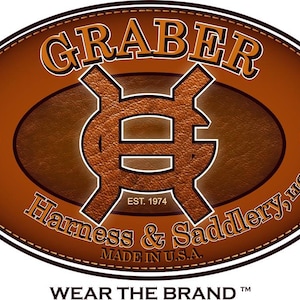 May include: A brown leather oval logo with the text "GRABER" in a white serif font. The logo also includes a stylized "G" symbol and the text "EST. 1974 Harness & Saddlery, LLC MADE IN U.S.A. WEAR THE BRAND TM".