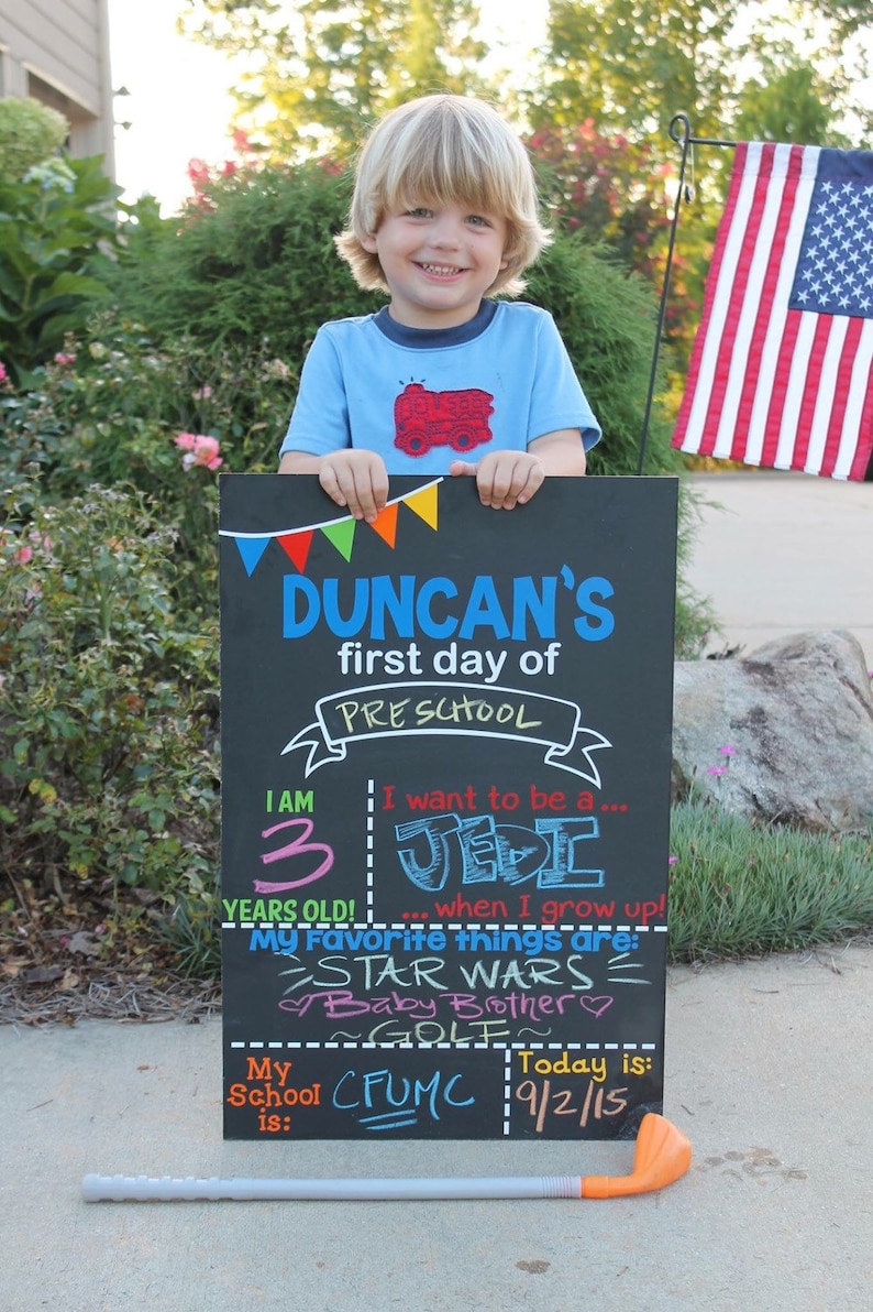 Child holding Reusable First Day of School Chalkboard Sign 