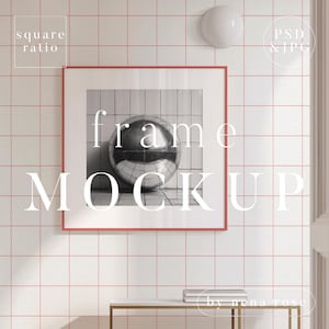 以下が含まれることがあります： 白いマットと銀色の球体の白黒写真が入った赤いフレームのモックアップ。フレームは赤い目地のある白いタイル張りの壁に掛けられています。写真には「frame mockup」という文字が白で書かれています。画像の左上隅には「square ratio」という文字が黒で書かれています。画像の右上隅には「PSD & JPG」という文字が黒で書かれています。画像の右下隅には「by rena rose」という文字が黒で書かれています。
