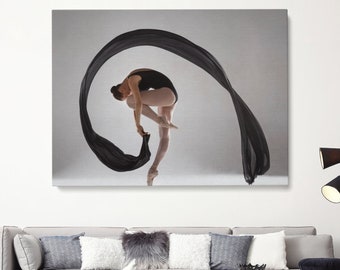 May include: A woman in a black leotard and pointe shoes dances with a flowing black fabric. The fabric is draped around her body and creates a circular shape. The background is a light gray.
