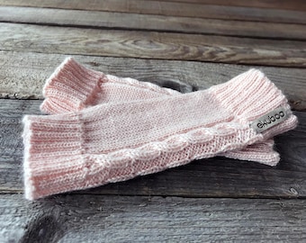 May include: A pair of pink knitted fingerless gloves with a cable knit pattern and a small silver tag that says "ekuboo".