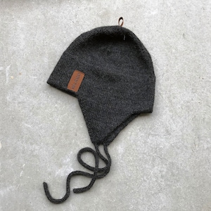 May include: A dark gray knitted hat with a leather label that says "Eldred" and a long black tie string.
