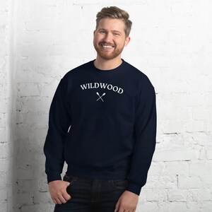 Może przedstawiać: Granatowa bluza z napisem "WILDWOOD" w białym kolorze i parą skrzyżowanych wiosłem pod spodem.