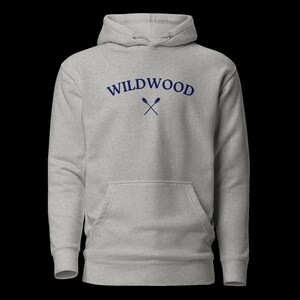 May include: A gray hooded sweatshirt with the text "WILDWOOD" in blue lettering and a pair of crossed oars in blue.