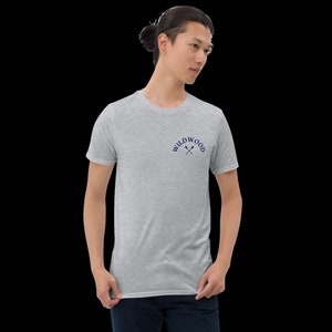 Puede incluir: Una camiseta gris jaspeada con un logotipo bordado en azul marino que dice "WILDWOOD" con dos remos cruzados.