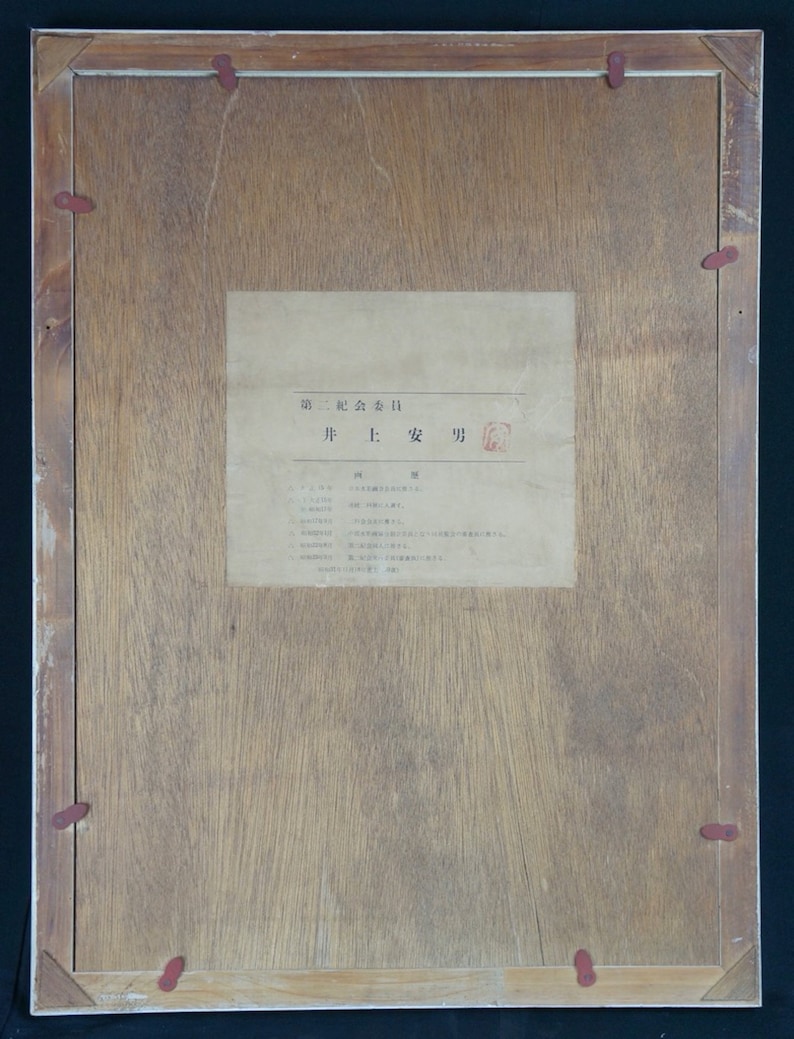 Puede incluir: Un marco de madera con una etiqueta de papel blanco en el interior. La etiqueta tiene texto japon&eacute;s que dice "第ニ記念会日" y "并 1: 安 功".