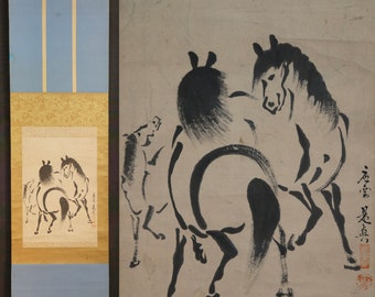 May include: A black and white ink painting on a beige background depicting three horses. The horses are in a dynamic pose, with one horse rearing up and the other two in a running position. The painting is signed in black ink in the lower right corner.