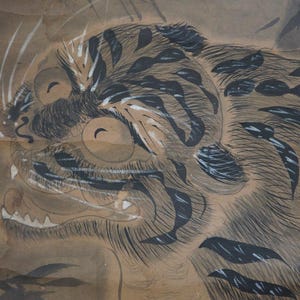 Peut inclure: Peinture à l'aquarelle détaillée d'une tête et du haut du corps d'un tigre. Le tigre a des rayures noires sur un fond beige, avec des accents blancs autour des yeux et de la bouche. L'œuvre est sur papier vieilli.