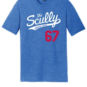 May include: A blue t-shirt with white text that reads "Vin Scully Since 1967" and a red number "67" on the front.