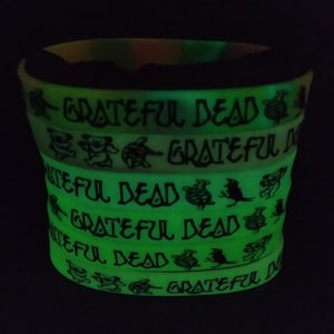 May include: A stack of glow-in-the-dark rubber bracelets with the words "Grateful Dead" and a dancing bear graphic.