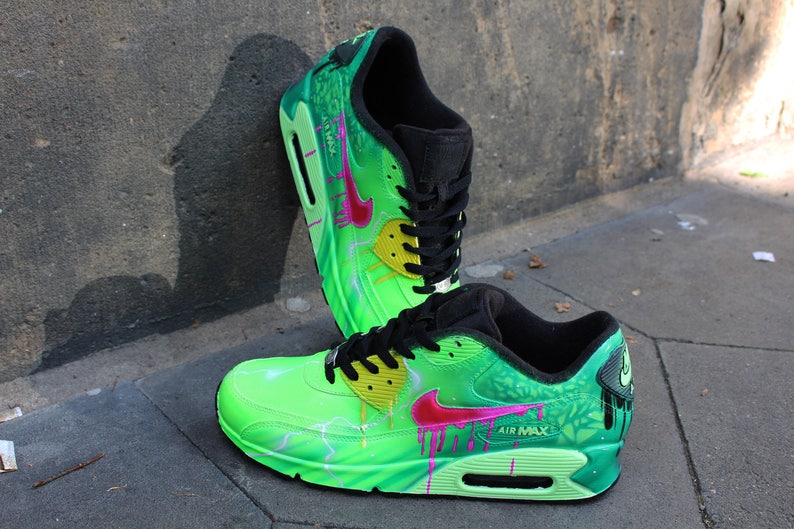 Puede incluir: Un par de zapatillas Nike Air Max 90 verdes, negras y rosas con un dise&ntilde;o de pintura personalizado. Las zapatillas presentan un patr&oacute;n de rayo, pintura goteando y un dise&ntilde;o floral.