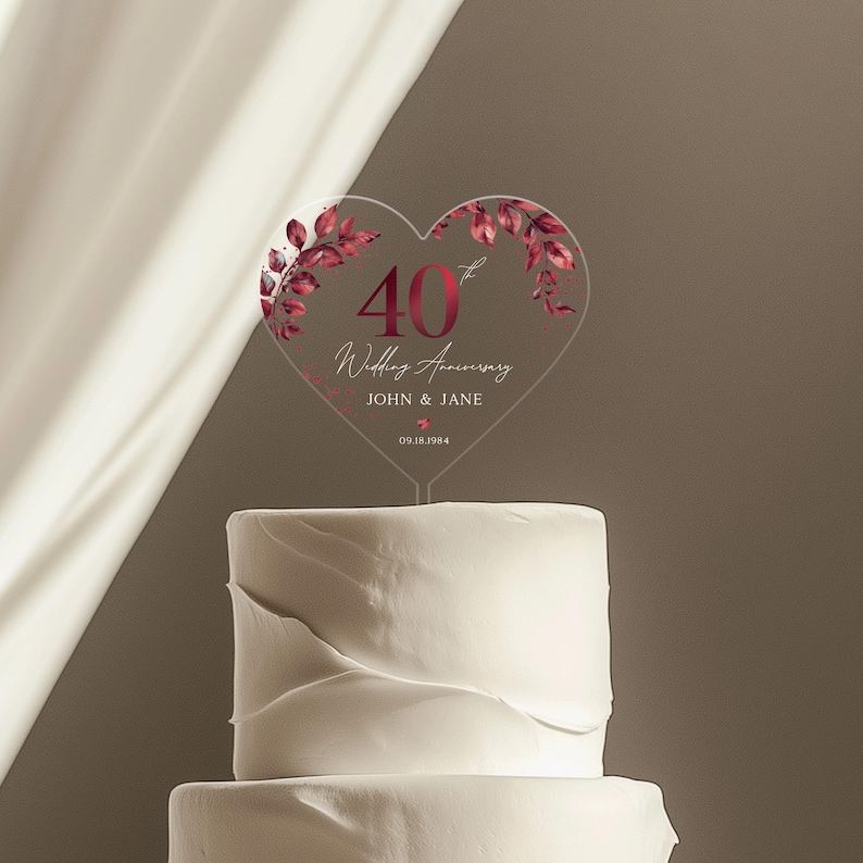 May include: A clear heart-shaped cake topper with a red 40th anniversary design. The topper features a red floral design and the text "40th Wedding Anniversary John & Jane 09.18.1984".