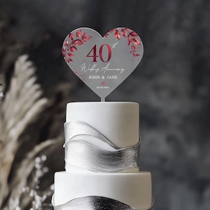 May include: A heart-shaped cake topper with a red 40th anniversary design. The topper features a red heart with the number 40, the words "Wedding Anniversary", and the names "John & Jane" with the date "09.18.1984".