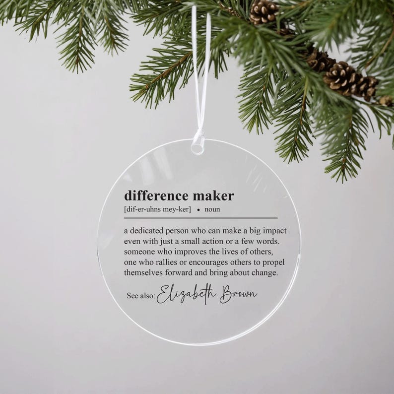 May include: A clear round bauble with the definition of "difference maker" and the name "Elizabeth Brown" printed on it.
