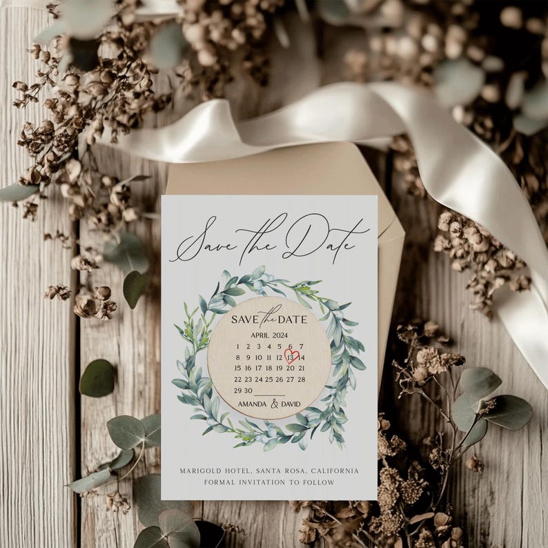 Puede incluir: Tarjeta de guardar la fecha con una corona de acuarela de hojas verdes y un c&iacute;rculo de calendario con un coraz&oacute;n rojo marcando el 12 de abril de 2024. El texto dice "Save the Date" y "Amanda & David".
